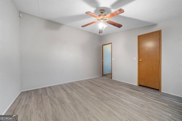 empty room with ceiling fan and light hardwood / wood-style floors