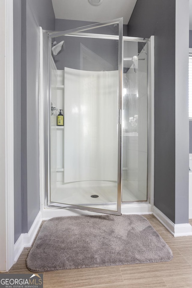 bathroom featuring hardwood / wood-style floors and a shower with shower door