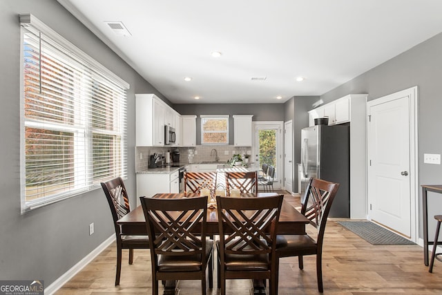 dining area featuring light wood-type flooring and sink