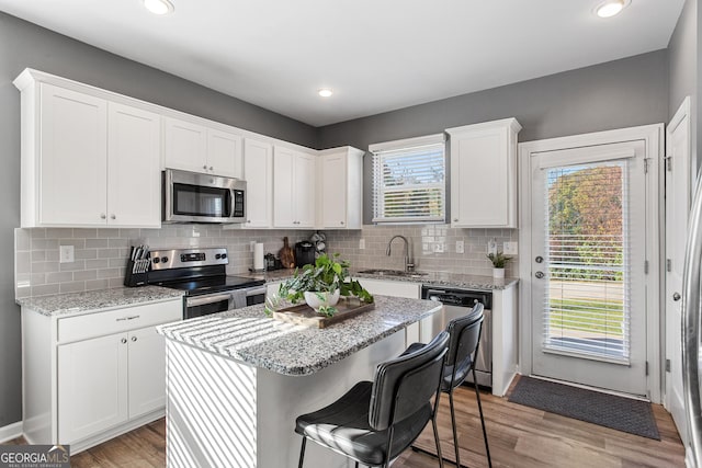 kitchen with white cabinetry, a healthy amount of sunlight, sink, and stainless steel appliances