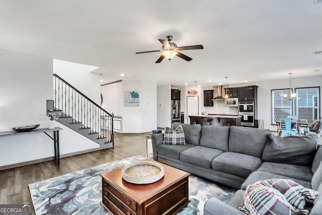 living room featuring hardwood / wood-style floors and ceiling fan with notable chandelier