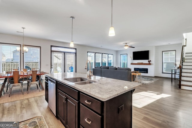 kitchen with light wood-type flooring, a healthy amount of sunlight, and an island with sink