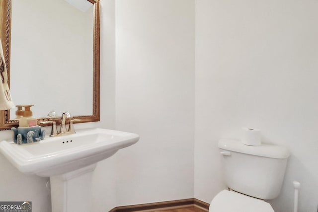 bathroom with hardwood / wood-style floors, toilet, and sink