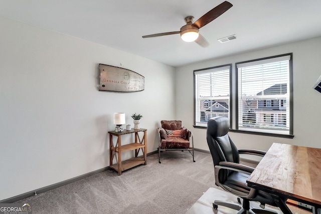 carpeted home office featuring ceiling fan