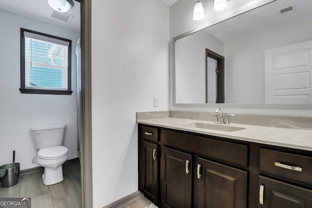 bathroom with hardwood / wood-style floors, vanity, and toilet