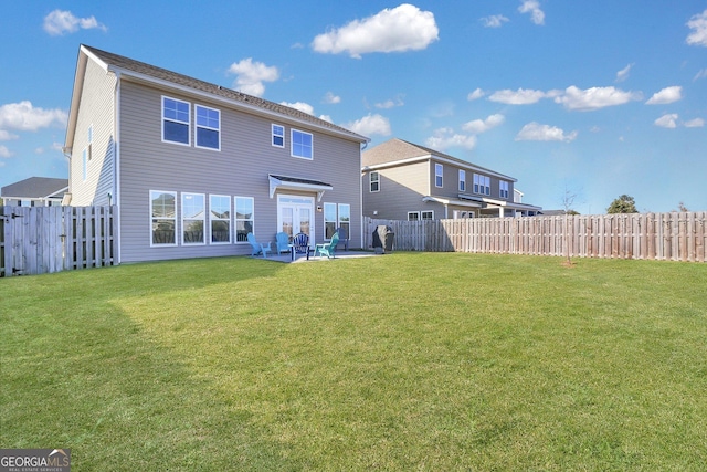 back of property with a yard and a patio