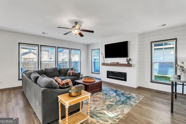 living room featuring ceiling fan, plenty of natural light, and wood-type flooring