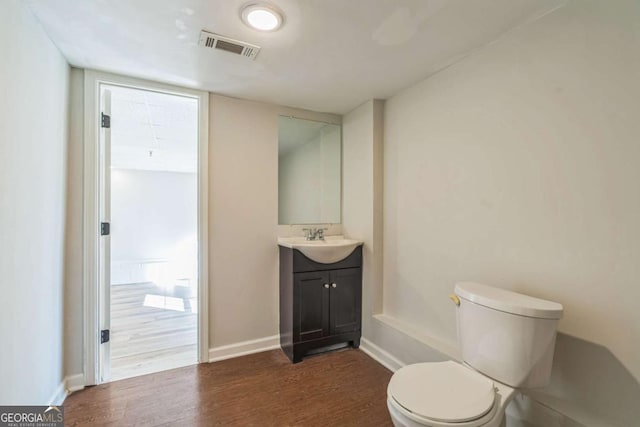 bathroom featuring wood-type flooring, vanity, and toilet