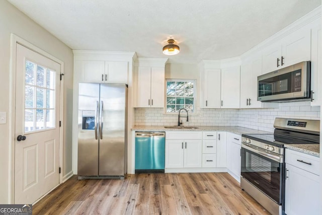 kitchen featuring appliances with stainless steel finishes, white cabinetry, and sink