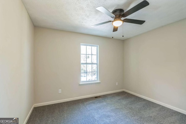 carpeted empty room with ceiling fan and a textured ceiling