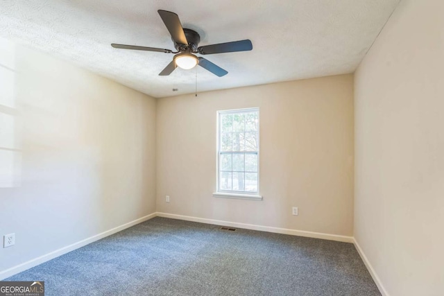 carpeted spare room featuring a textured ceiling and ceiling fan