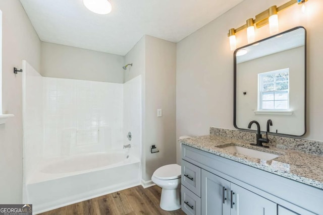 full bathroom featuring vanity, toilet, washtub / shower combination, and hardwood / wood-style flooring