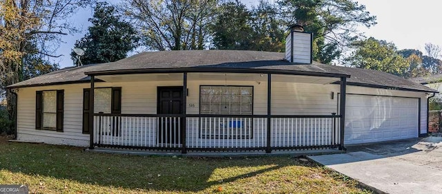 exterior space featuring covered porch, a garage, and a front yard