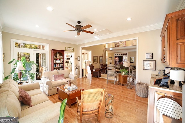 living room featuring ceiling fan, light hardwood / wood-style floors, and crown molding