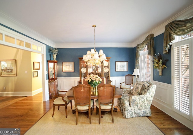 dining area featuring crown molding, a chandelier, and light wood-type flooring