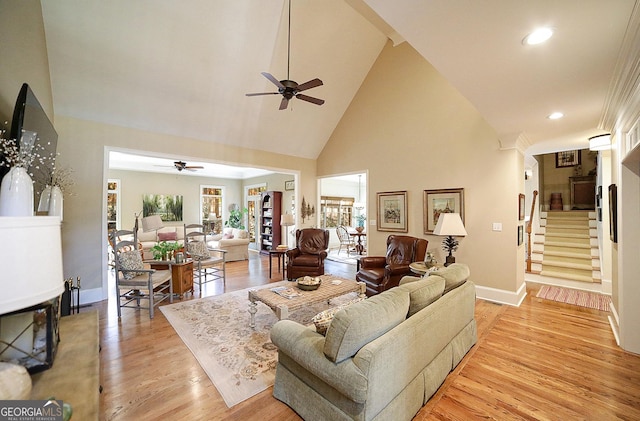 living room featuring ceiling fan, high vaulted ceiling, and light hardwood / wood-style floors