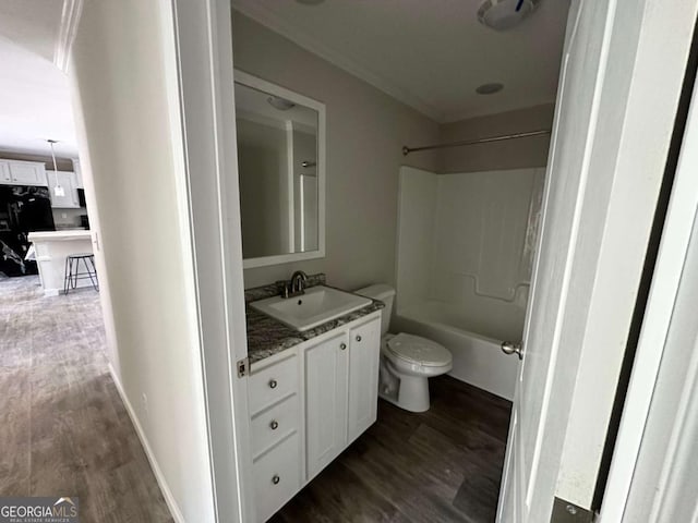 bathroom with vanity, toilet, baseboards, bathing tub / shower combination, and wood finished floors