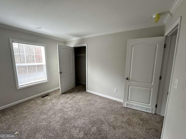 unfurnished bedroom with carpet flooring, crown molding, baseboards, and visible vents