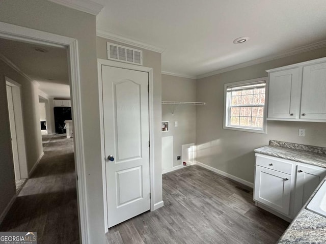 laundry area with cabinets, wood-type flooring, ornamental molding, and washer hookup