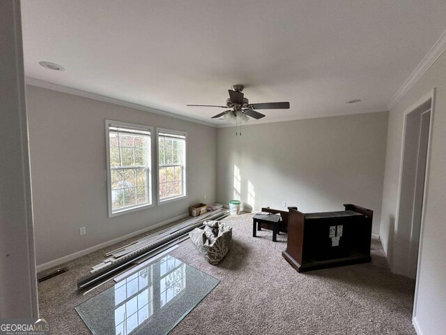 interior space with crown molding, carpet floors, baseboards, visible vents, and ceiling fan