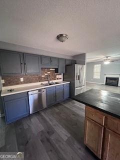 kitchen with appliances with stainless steel finishes, backsplash, dark hardwood / wood-style floors, and sink