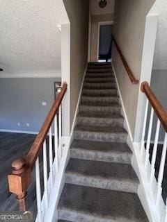 stairway featuring a textured ceiling