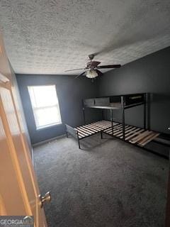 unfurnished bedroom with ceiling fan, carpet, and a textured ceiling