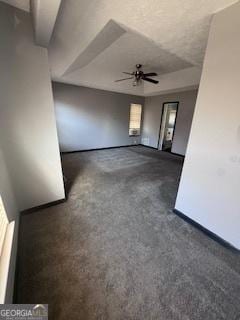 unfurnished living room with dark carpet and ceiling fan