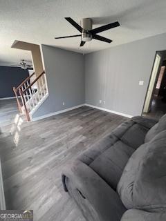 unfurnished living room with ceiling fan and wood-type flooring