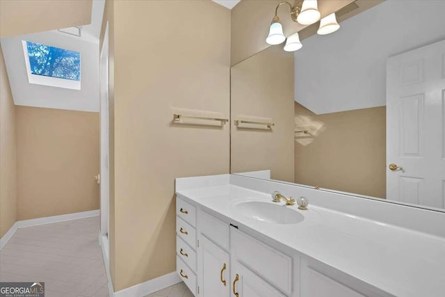 bathroom with tile patterned floors, a skylight, and vanity