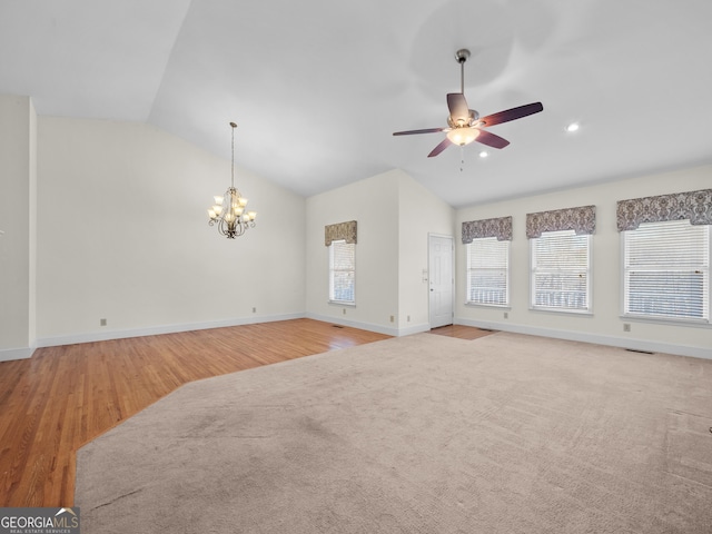 unfurnished living room featuring ceiling fan with notable chandelier, light hardwood / wood-style flooring, and lofted ceiling