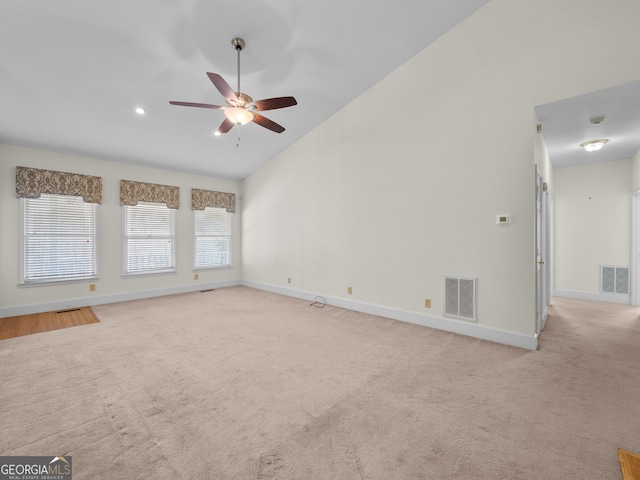 carpeted empty room with high vaulted ceiling and ceiling fan