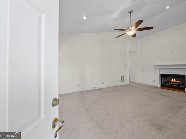 unfurnished living room featuring light colored carpet, ceiling fan, and lofted ceiling