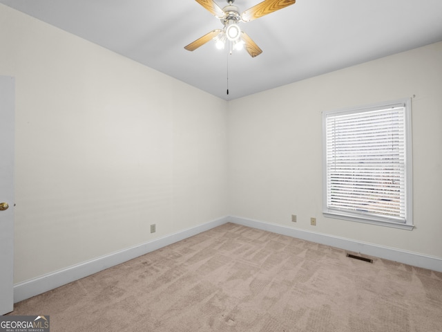 empty room with ceiling fan and light colored carpet