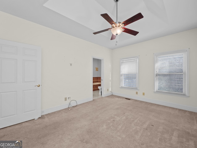 unfurnished bedroom featuring connected bathroom, ceiling fan, and light colored carpet