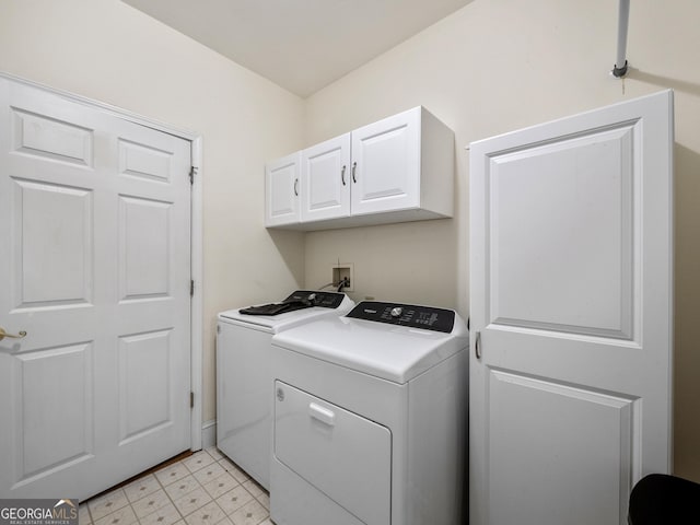 washroom featuring cabinets and washer and clothes dryer