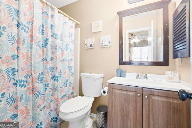 bathroom featuring a shower with shower curtain, vanity, and toilet