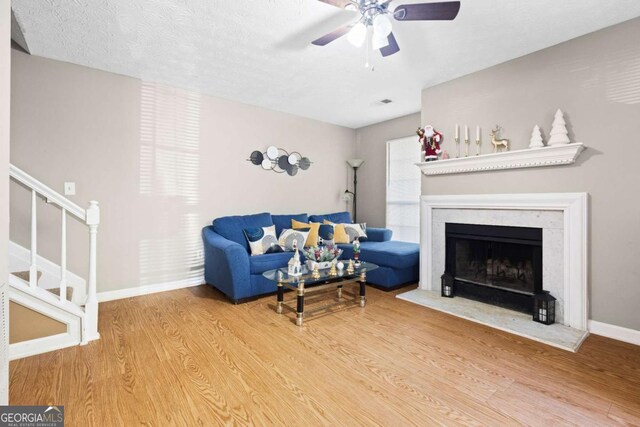 living room with ceiling fan, hardwood / wood-style floors, and a textured ceiling