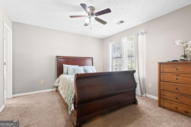 carpeted bedroom featuring a textured ceiling and ceiling fan