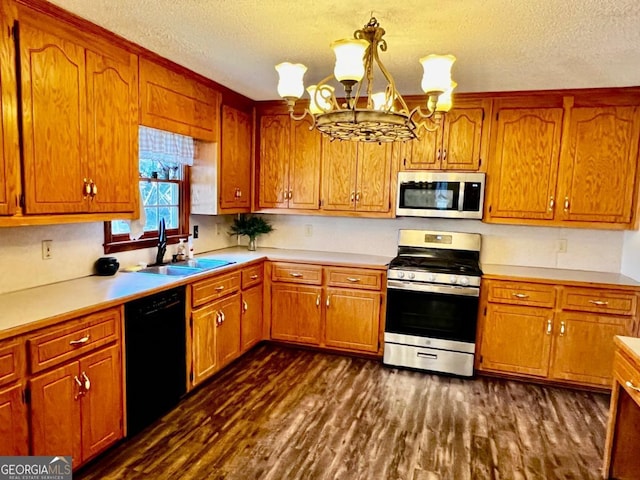 kitchen featuring sink, stainless steel appliances, dark hardwood / wood-style floors, a chandelier, and a textured ceiling