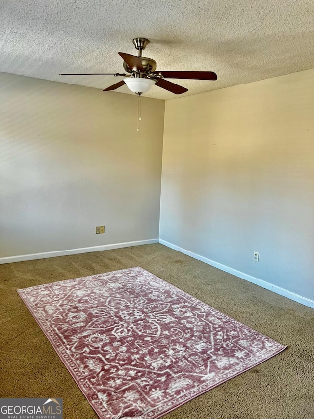 carpeted spare room featuring a textured ceiling and ceiling fan