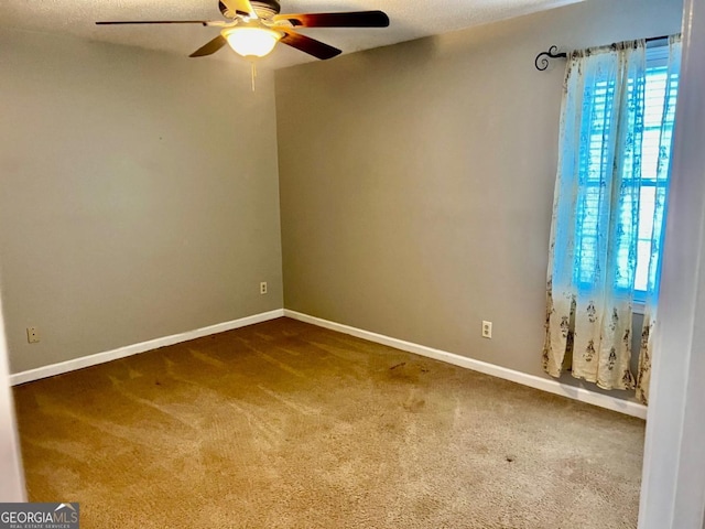 empty room with ceiling fan, carpet, and a textured ceiling