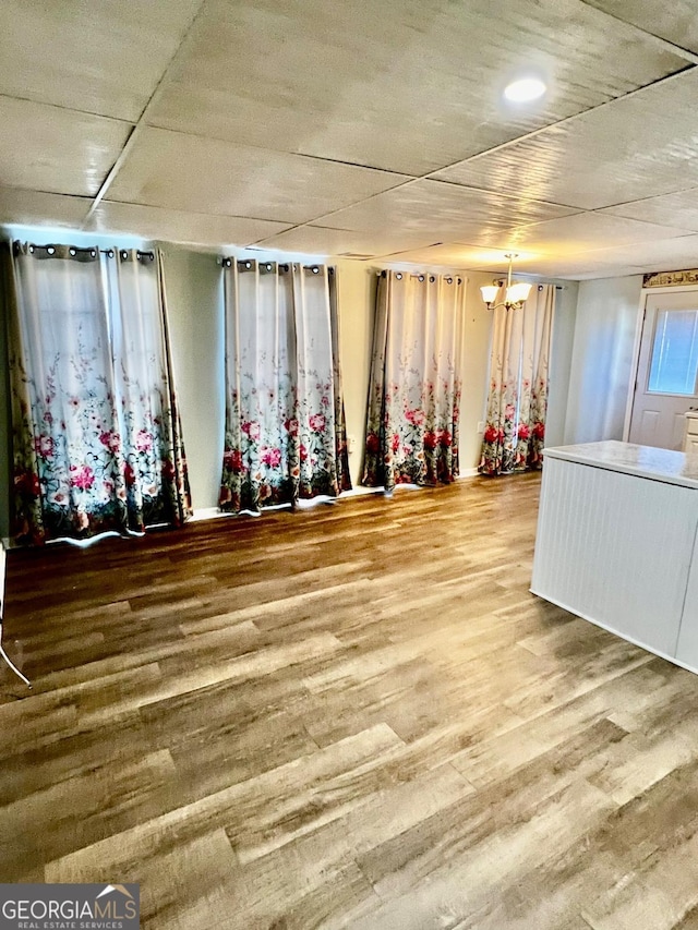 basement with hardwood / wood-style floors and a chandelier