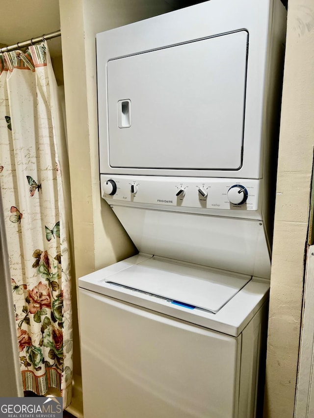 laundry area with stacked washer and dryer