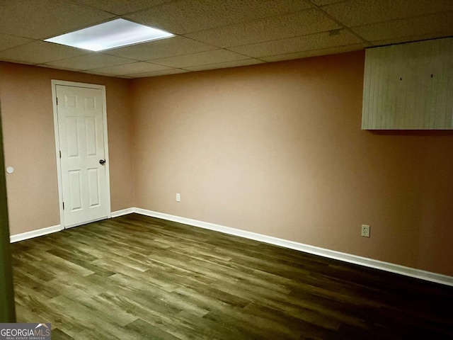 unfurnished room with wood-type flooring and a paneled ceiling