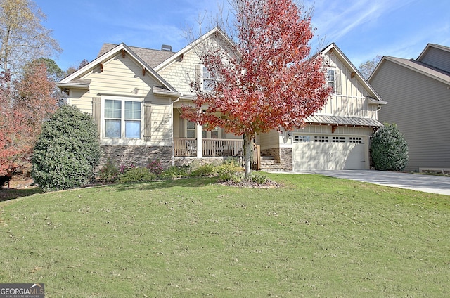 view of front of house featuring a porch, a garage, and a front lawn