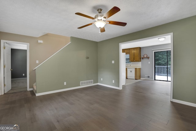 unfurnished living room with a textured ceiling, ceiling fan, and dark wood-type flooring