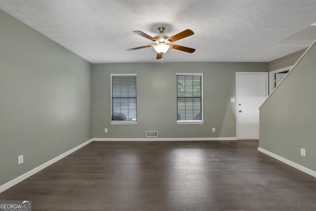 spare room with a textured ceiling, dark hardwood / wood-style flooring, and ceiling fan