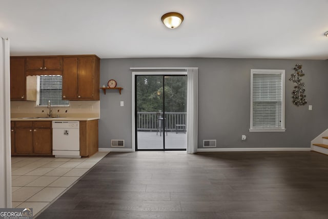 kitchen featuring white dishwasher, light hardwood / wood-style floors, and sink