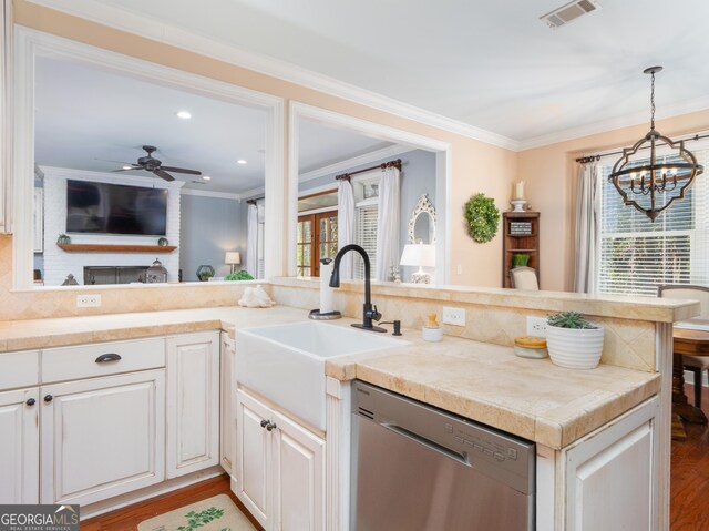 kitchen featuring ornamental molding, sink, stainless steel dishwasher, and light wood-type flooring